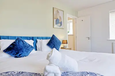 a bedroom with a white bed with blue pillows at Spacious Colchester Home with Off-Street Parking for 4 cars in Colchester