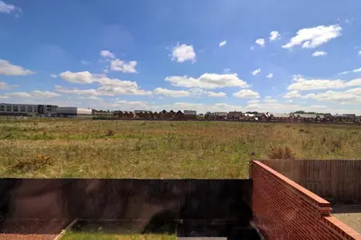 a train traveling through a field with a fence at Spacious Colchester Home with Off-Street Parking for 4 cars in Colchester