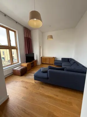 a living room with a blue couch and a television at Spacious 4 Bedroom Townhouse in Essex in Burnt Mill