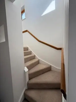 a staircase in a home with white walls and brown carpet at Spacious 4 Bedroom Townhouse in Essex in Burnt Mill