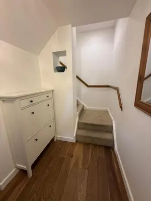 a room with a staircase with a dresser and a stair case at Spacious 4 Bedroom Townhouse in Essex in Burnt Mill