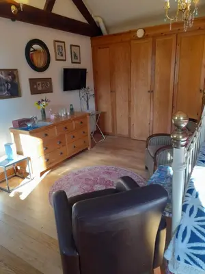 a living room with a couch and a tv at Wisteria Barn in Harleston