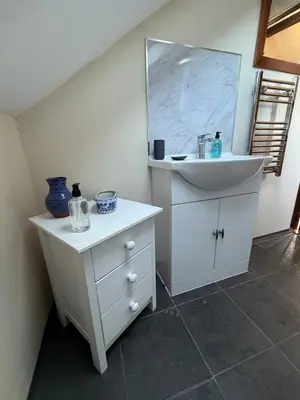 a white bathroom with a sink and a mirror at The Lodge in Prickwillow