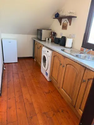 a kitchen with a washing machine and a sink at The Lodge in Prickwillow