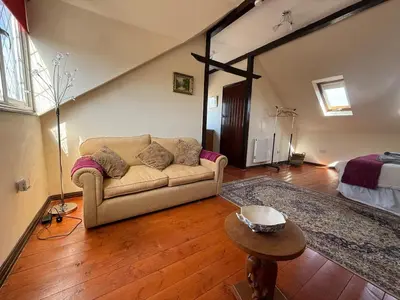 a living room with a couch and a bed at The Lodge in Prickwillow