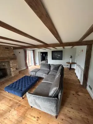 a large living room with a couch and a fireplace at Bakers Cottage, Blackmore End in Gosfield