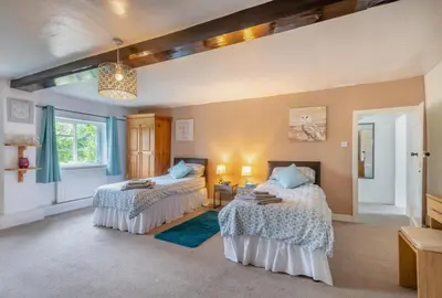 a bedroom with two beds and a chandelier at 4 Bed in East Harling oc-m31907 in East Harling