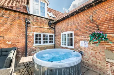 a hot tub in the courtyard of a brick building at 4 Bed in East Harling oc-m31907 in East Harling
