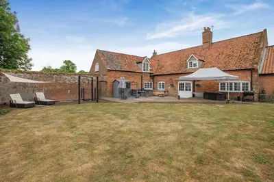 an external view of a large brick house with a yard at 4 Bed in East Harling oc-m31907 in East Harling