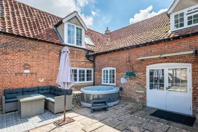 a hot tub in the courtyard of a brick house at 4 Bed in East Harling oc-m31907 in East Harling