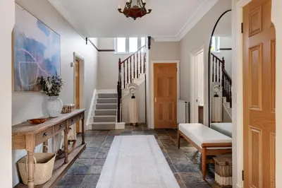 a hallway with a table and a stairway at Merry Lakes - Luxury Lakeside Escape with Pool - Just 30 Minutes from London in Hutton
