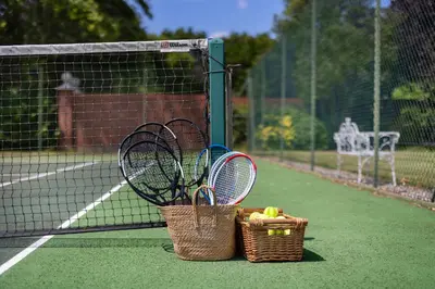 two baskets of tennis rackets on a tennis court at Merry Lakes - Luxury Lakeside Escape with Pool - Just 30 Minutes from London in Hutton
