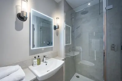 a bathroom with a sink and a glass shower at The Ship Hotel in Southend-on-Sea