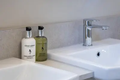 a bathroom with two bottles of soap and a sink at The Ship Hotel in Southend-on-Sea