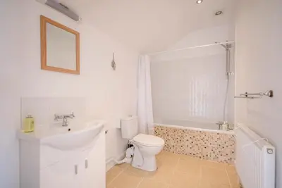 a bathroom with a sink and a toilet and a bath tub at The Old Dairy, Cookley in Cookley