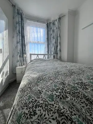 a bedroom with a bed with a black and white bedspread at Dolce Vita on Sea in Southend-on-Sea