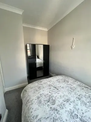 a bedroom with a large bed and a mirror at Dolce Vita on Sea in Southend-on-Sea