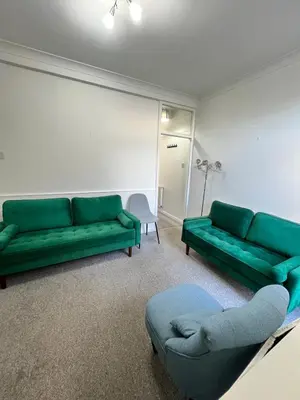 a living room with two green couches and a couch at Dolce Vita on Sea in Southend-on-Sea