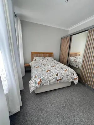 a bedroom with a bed and a large mirror at Dolce Vita on Sea in Southend-on-Sea