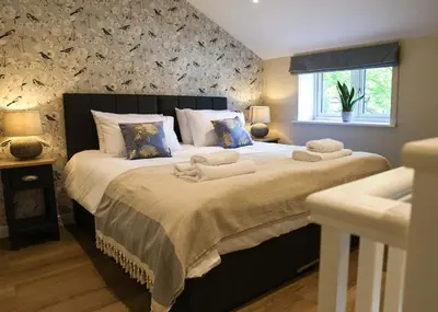 a bedroom with a large bed with towels on it at Gala Suite - The Apple Barn in Pettistree