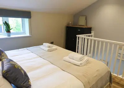 a bedroom with a large bed with towels on it at Gala Suite - The Apple Barn in Pettistree