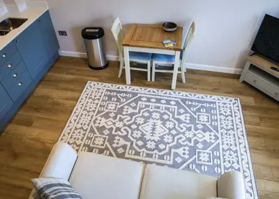 a living room with a table and a rug at Gala Suite - The Apple Barn in Pettistree