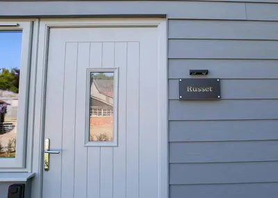 a garage door with a house sign on it at Russet Suite - The Apple Barn in Pettistree