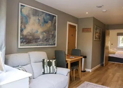 a living room with a couch and a table at Russet Suite - The Apple Barn in Pettistree