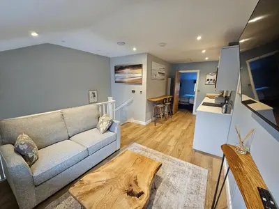 a living room with a couch and a table at Discovery Suite - The Apple Barn in Pettistree