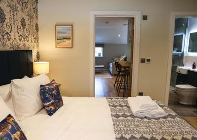 a bedroom with a bed and a bathroom at Discovery Suite - The Apple Barn in Pettistree