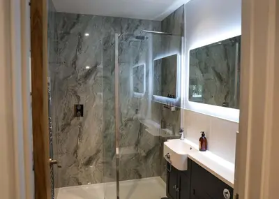 a bathroom with a glass shower and a sink at Discovery Suite - The Apple Barn in Pettistree