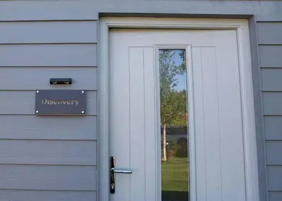 a door to a house with a sign on it at Discovery Suite - The Apple Barn in Pettistree