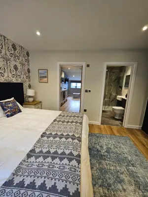 a bedroom with a large bed and a bathroom at Discovery Suite - The Apple Barn in Pettistree
