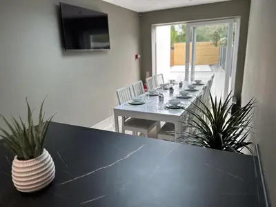 a dining room with a black table with plants on it at Abbey Rooms in Waltham Abbey