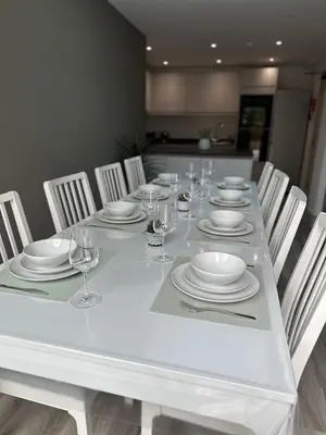a white table with chairs and plates and wine glasses at Abbey Rooms in Waltham Abbey