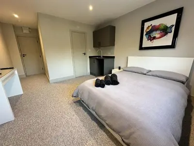 a bedroom with a large bed with shoes on it at Abbey Rooms in Waltham Abbey