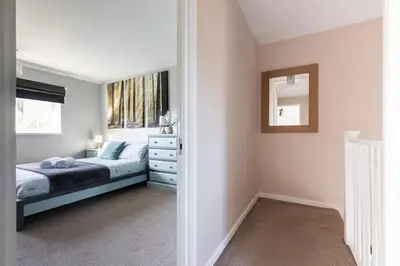 a bedroom with a bed and a dresser and a mirror at Clicketts - 3-Bedroom, Full Entire House, Sleeps 6 guests, Free wifi, Street Parking, Smart TV, Basildon, Essex London in Basildon