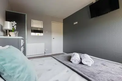 a bedroom with two towels sitting on a bed at Clicketts - 3-Bedroom, Full Entire House, Sleeps 6 guests, Free wifi, Street Parking, Smart TV, Basildon, Essex London in Basildon