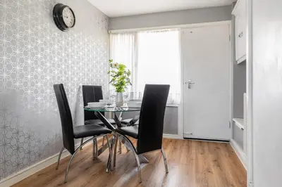 a dining room with a glass table and black chairs at Clicketts - 3-Bedroom, Full Entire House, Sleeps 6 guests, Free wifi, Street Parking, Smart TV, Basildon, Essex London in Basildon