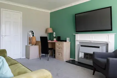 a living room with a television above a fireplace at Clicketts - 3-Bedroom, Full Entire House, Sleeps 6 guests, Free wifi, Street Parking, Smart TV, Basildon, Essex London in Basildon