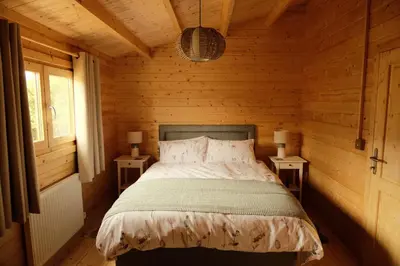 a bedroom with a bed with two night stands at Welhams Meadow Holiday Lodges in Ringshall