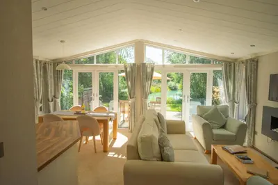 a living room with a couch and a dining room at Welhams Meadow Holiday Lodges in Ringshall