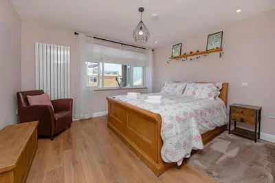 a bedroom with a bed and a chair at Coastal Charm In Clacton On Sea in Holland-on-Sea
