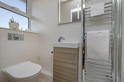 a white bathroom with a toilet and a sink at Coastal Charm In Clacton On Sea in Holland-on-Sea