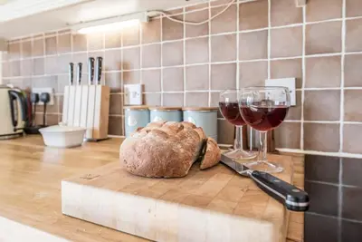 a loaf of bread and two glasses of wine on a cutting board at The Meadows Dairy, Bawdsey in Bawdsey