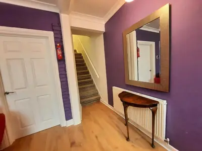 a hallway with purple walls and a mirror and a chair at Cozy Seaview Flat in Clacton-on-Sea