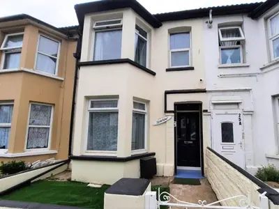 a white house with a black door at Cozy Seaview Flat in Clacton-on-Sea