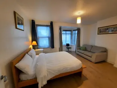 a bedroom with a large bed and a couch at Cozy Seaview Flat in Clacton-on-Sea