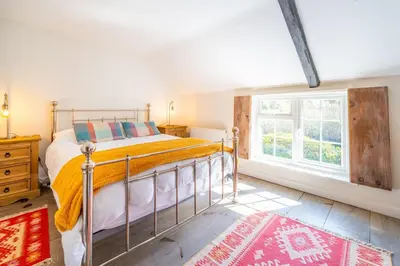 a bedroom with a bed and a window at 5 Mill Cottage in Yoxford
