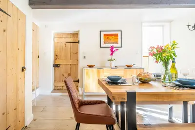 a dining room with a wooden table and chairs at 5 Mill Cottage in Yoxford